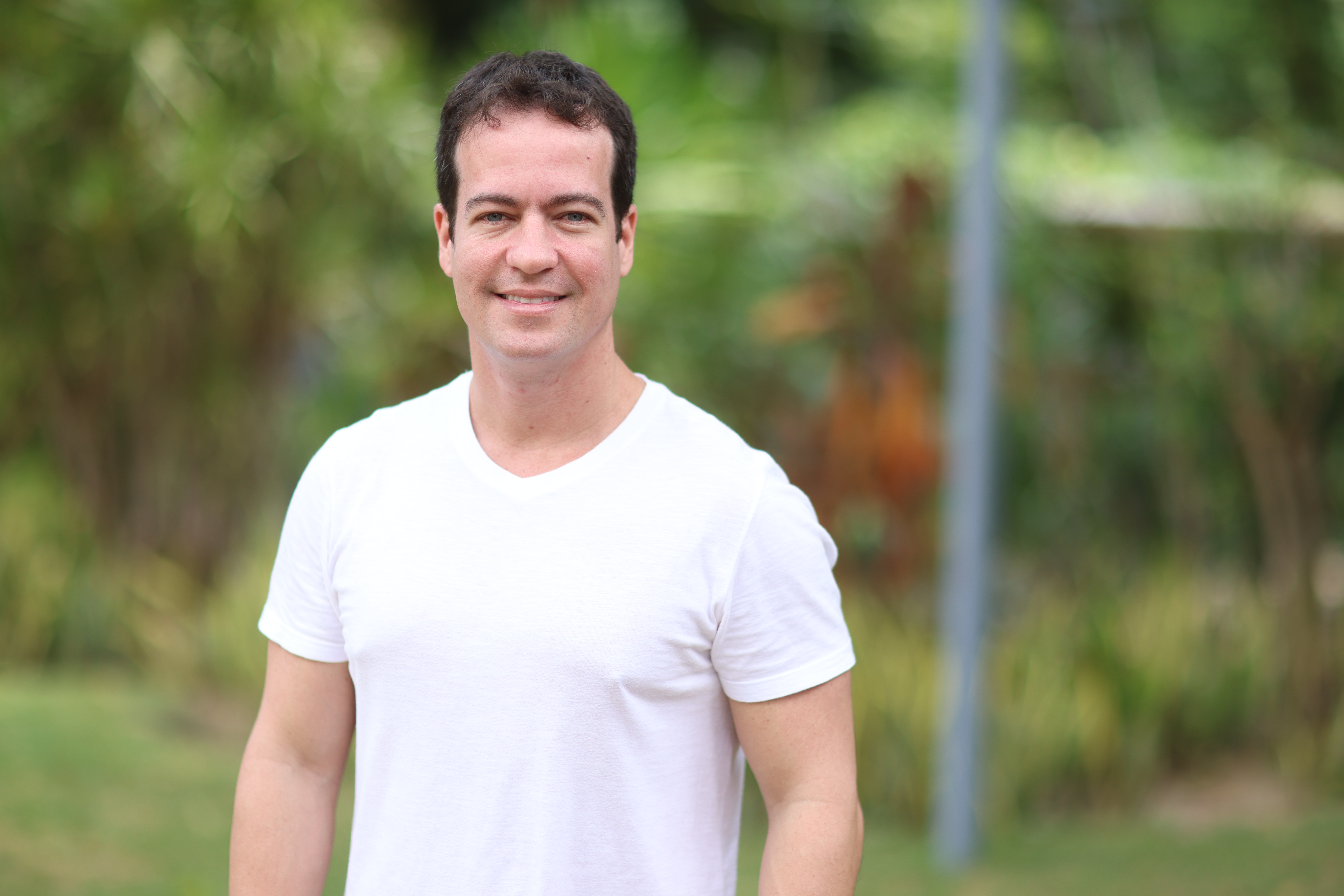 Julioz Brizzi posa para a foto, ele usa uma camiseta branca